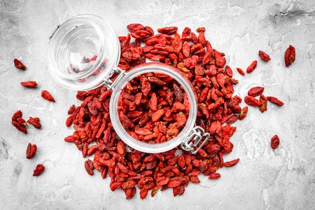 Dried goji berries in glass jar on grey top viewの写真素材