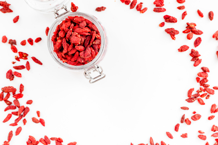Dried goji berries in glass jar on white background top view.の写真素材