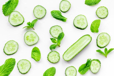 Skin care at home. Sliced cucumber pattern on white background top view.の写真素材