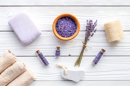 Set for foot spa with lavender. Flowers, spa salt, pumice stone, soap on white wooden background top view.の写真素材