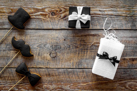 Birthday gift for men. Wrapped box and cookies in shape of black tie, mustache and hat. Wooden...