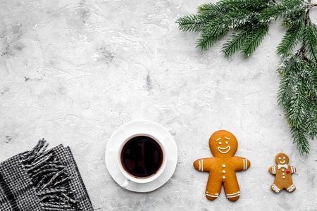 Coffee with gingebread cookies in christmas evening. Cup near spruce branch on grey wooden background top view.の写真素材