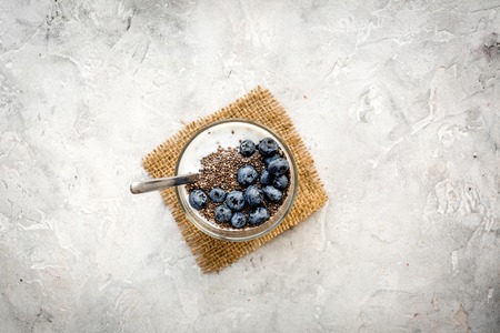 How to eat chia seeds. Dessert with yogurt, chia and blueberries on grey background top view.の写真素材