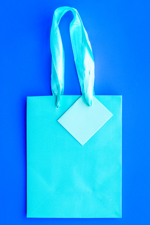 Turquoise bright shopping bag on blue background top view mockupの写真素材