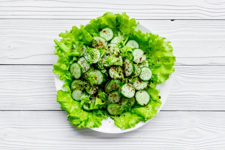 Salad with fresh cucumbers and lettuce. Grey wooden background top view copyspaceの写真素材