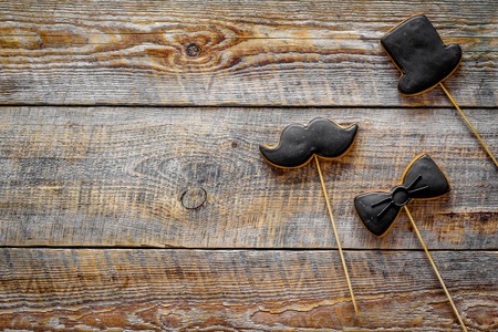 Men birthday concept. Set of cookies in shape of black tie, mustache and hat. Wooden background top view.の写真素材
