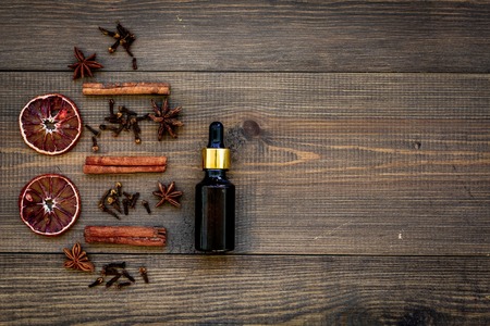 Skin care and relax. Cosmetics and aromatherapy concept. Cinnamon oil on dark wooden background top view copyspaceの写真素材