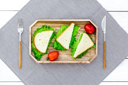 Sandwiches with lettuce for picnic on tablecloth on white wooden table background top viewの写真素材