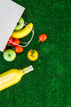 Fruits for picnic. Apple, banana, tangerine on green grass background top view copyspaceの写真素材