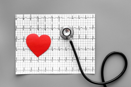 Examine the heart to prevent heart disease. Heart sign, cardiogram, stethoscope on grey background top viewの写真素材