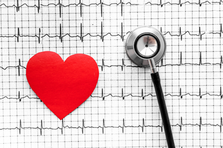 Examine the heart to prevent heart disease. Heart sign and stethoscope on cardiogram background top viewの写真素材
