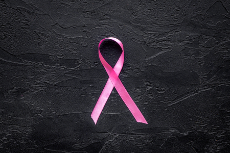 Pink ribbon for breast cancer awareness on black background top view copyspaceの写真素材