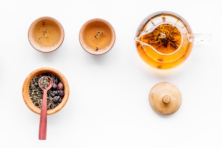 Tea ceremony concept. Tea pot, cups or bowls, dry tea leaves on white background top view pattern copyspaceの写真素材