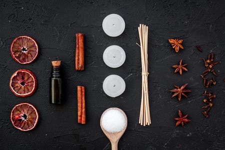 Aromatherapy for relax concept. Spa salt, candles and oil with spices cinnamon on black background top viewの写真素材