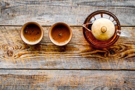 Tea break. Cookware fo tea ceremony. Tea pot and cups on rustic wooden background top view copyspaceの写真素材