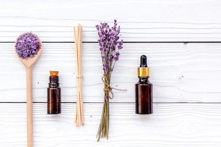 Aromatherapy for relax concept. Lavender branch, spa salt and oil on white wooden background top view.の写真素材