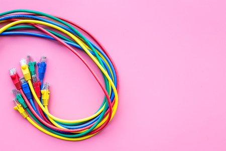 Network colored cables for computer on pink background top view copyspace