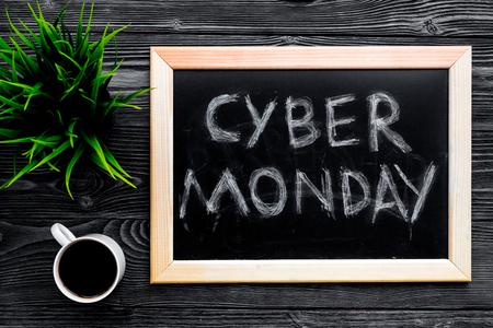 Words cyber monday written on blackboard near keyboard on grey wooden background top view