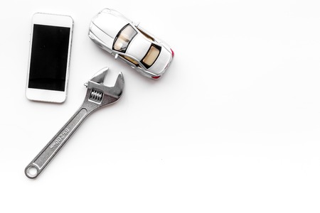 Choose car service. Wrench near car toys and cell phone on white background top view copyspaceの写真素材