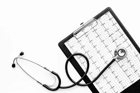 To diagnose heart disease. Cardiogram, stethoscope on white background top view.