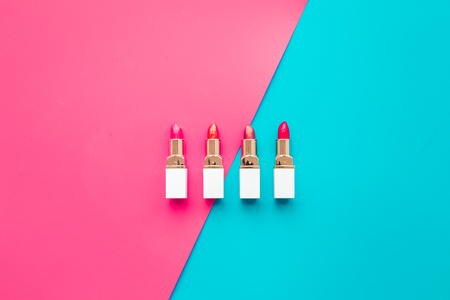 Lipsticks assorted colors on blue and pink background top view copyspaceの写真素材
