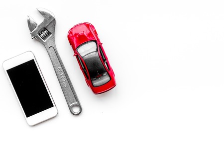 Choose car service. Wrench near car toys and cell phone on white background top view copyspaceの写真素材