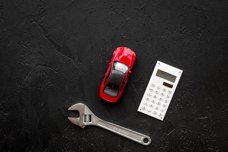Price of car repair. Wrench near car toys and calculator on black background top view copyspaceの写真素材