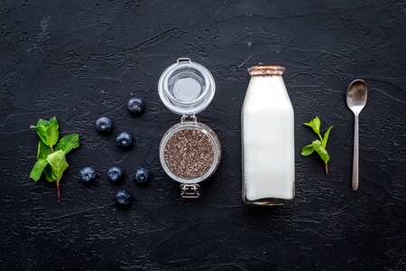 Light dessert with chia seeds, yogurt, blueberry and mint. Black background top viewの写真素材