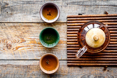 Set for tea ceremony. Glass teapot and ceramic cups on rustic wooden background top view copyspaceの写真素材