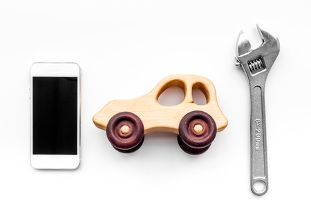 Choose car service. Wrench near car toys and cell phone on white background top viewの写真素材