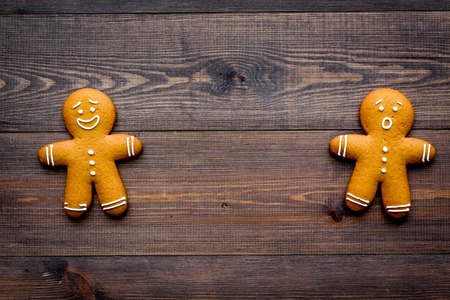 Gingerbread man cookies on wooden background top view.