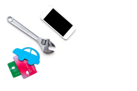 Search car service online. Mobile pay. Car silhouette, wrench, cell phone, bank card on white backgound top view copy spaceの写真素材