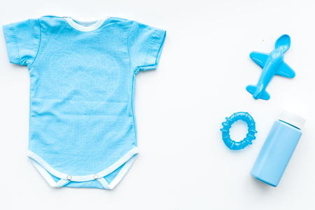 Blue baby clothes for little boy. Bodysuit, toys, cosmetics on white background top view copy spaceの写真素材