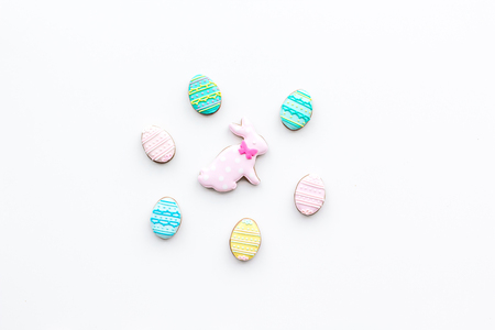 Easter background. Cookies in shape of easter bunny and easter eggs. White background top view space...