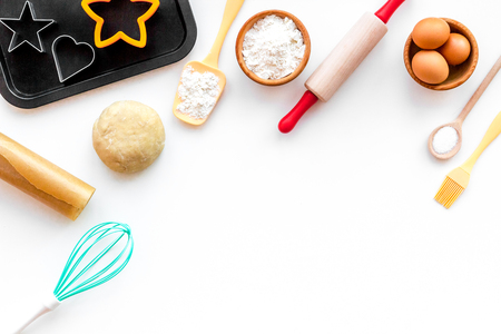Roll out the dough. Dough ball near roller pin and other cookware on white background top view.の写真素材