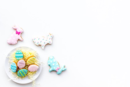 Easter background. Cookies in shape of easter bunny and easter eggs. White background top view.の写真素材