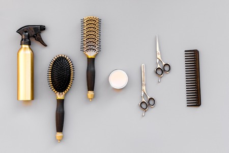 Professional hairdressing tools in beauty saloon. Combs, spray, sciccors on grey background top view.の写真素材