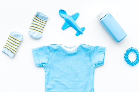 Blue set for newborn boy. Baby bodysuit, socks, airplan toy and powder on white background top viewの写真素材