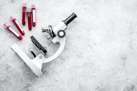 Blood test concept. Blood samples near microscope on grey background top view.の写真素材