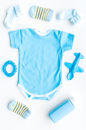 Blue set for newborn boy. Baby bodysuit, socks, airplan toy and powder on white background top view.の写真素材
