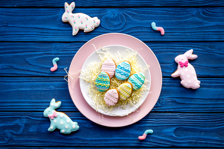 Easter bunny and easter eggs cookies. Sweets, pastry for Easter table. Blue wooden background top...
