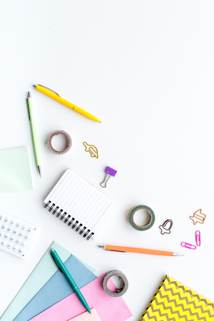 Scattered stationery on student's desk. White background top view.の写真素材