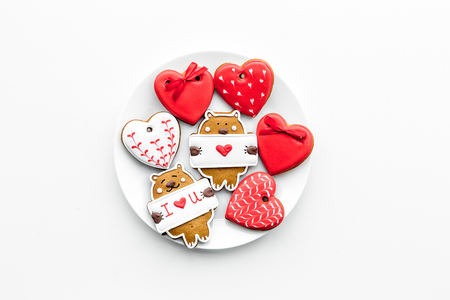 Sweet gift on Valentine's Day. Heart shaped cookies and bear with lettering I love you on white background top view.の写真素材