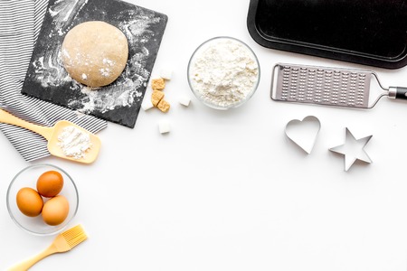 Ball of fresh raw dough near ingedients and cookware on white background top view.の写真素材