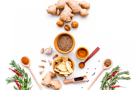 Seasoning background. Dry spices near ginger, garlic, rosemary on white background top view copy spaceの写真素材