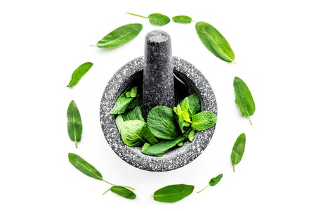 Herbal medicine. Herbs in mortar bowl on white background top view.の写真素材