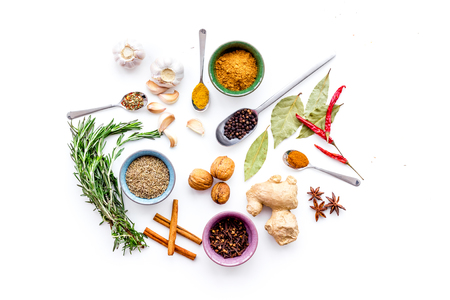 Seasoning background. Dry spices near ginger, garlic, rosemary on white background top view.の写真素材