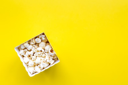 Popcorn in paper bag on yellow background top view copy spaceの写真素材