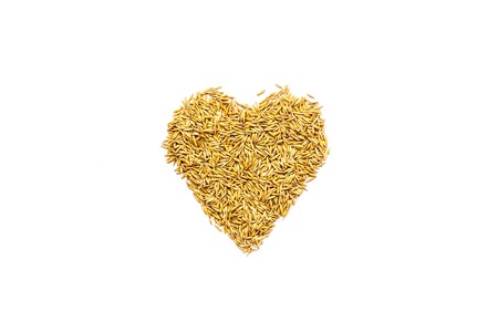 Raw oats in shape of heart on white background top view.の写真素材