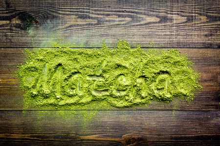 Word Matcha writed at matcha powder on dark wooden background top view.の写真素材